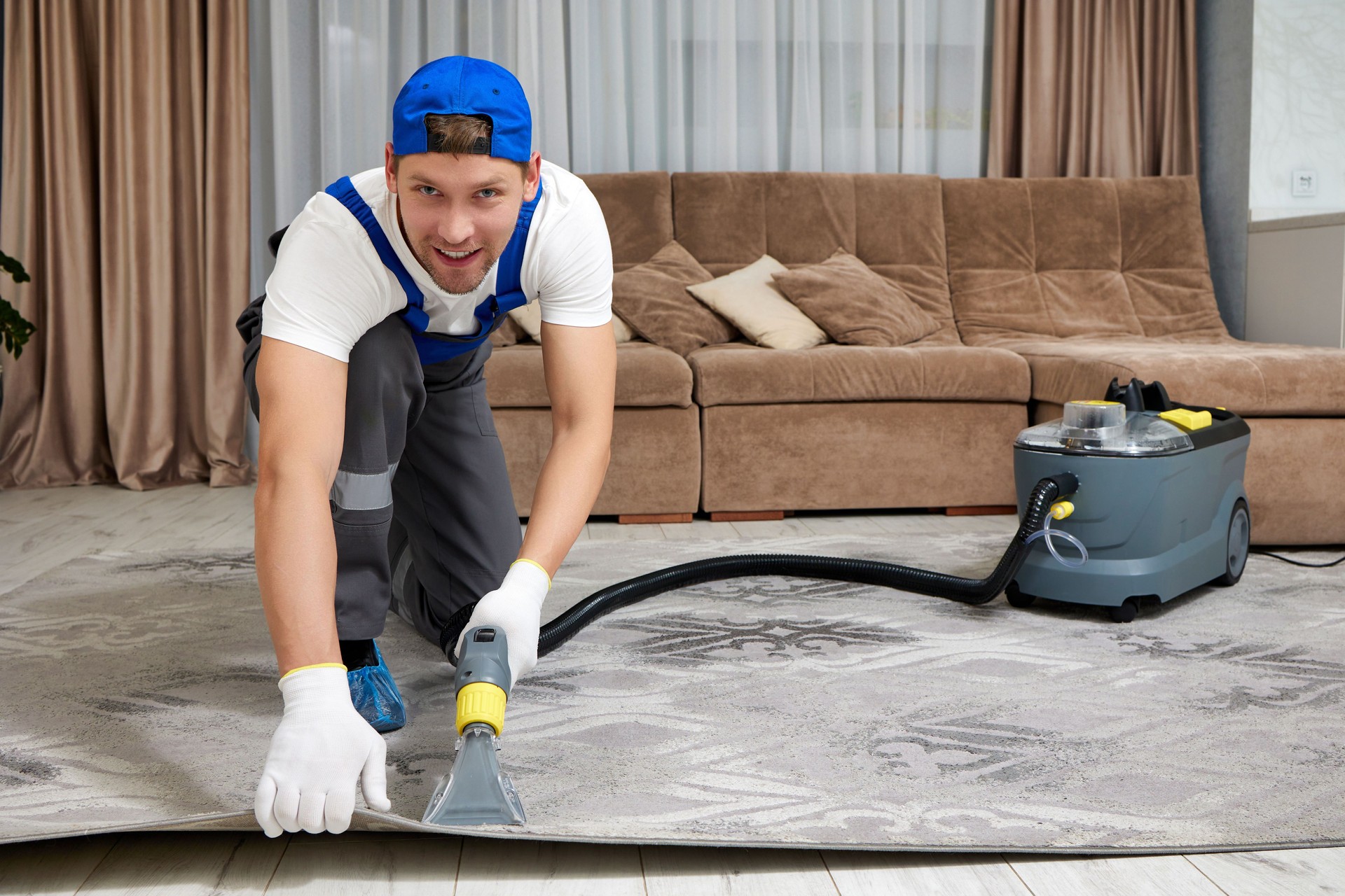 Specialized cleaning company worker using vacuum cleaner on carpet in large residence