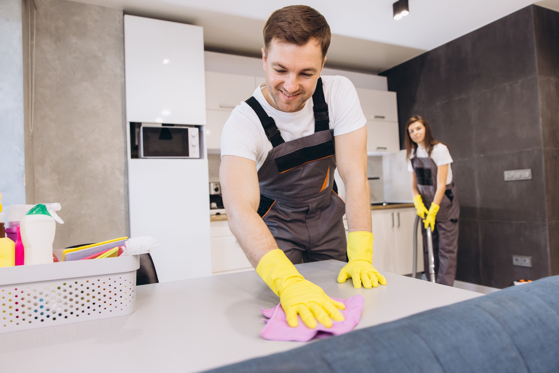 Cleaning company employees cleaning kitchen table and floor
